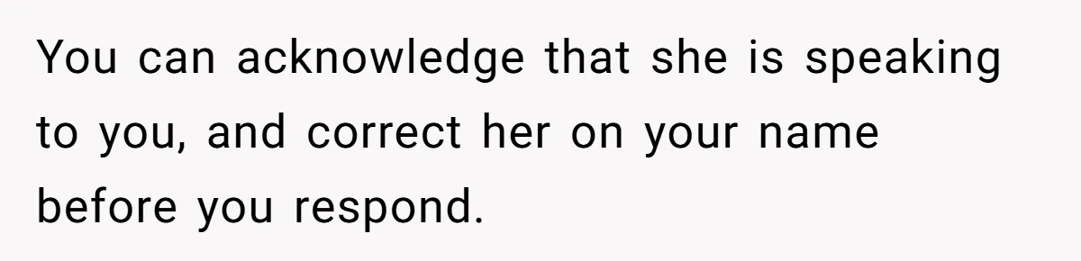 You can acknowledge that she is speaking to you, and correct her on your name before you respond.
