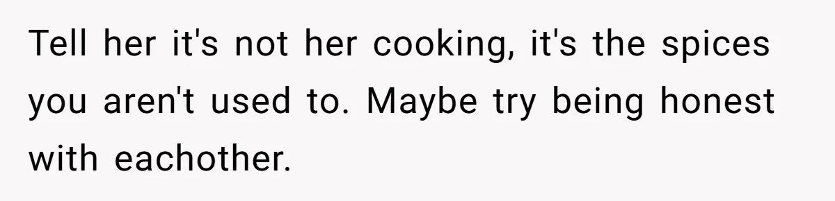 Tell her it's not her cooking, it's the spices you aren't used to. Maybe try being honest with eachother.